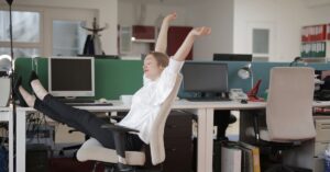 Woman leaning back & stretching in office chair
