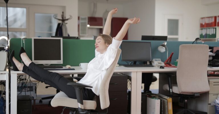 Woman leaning back & stretching in office chair